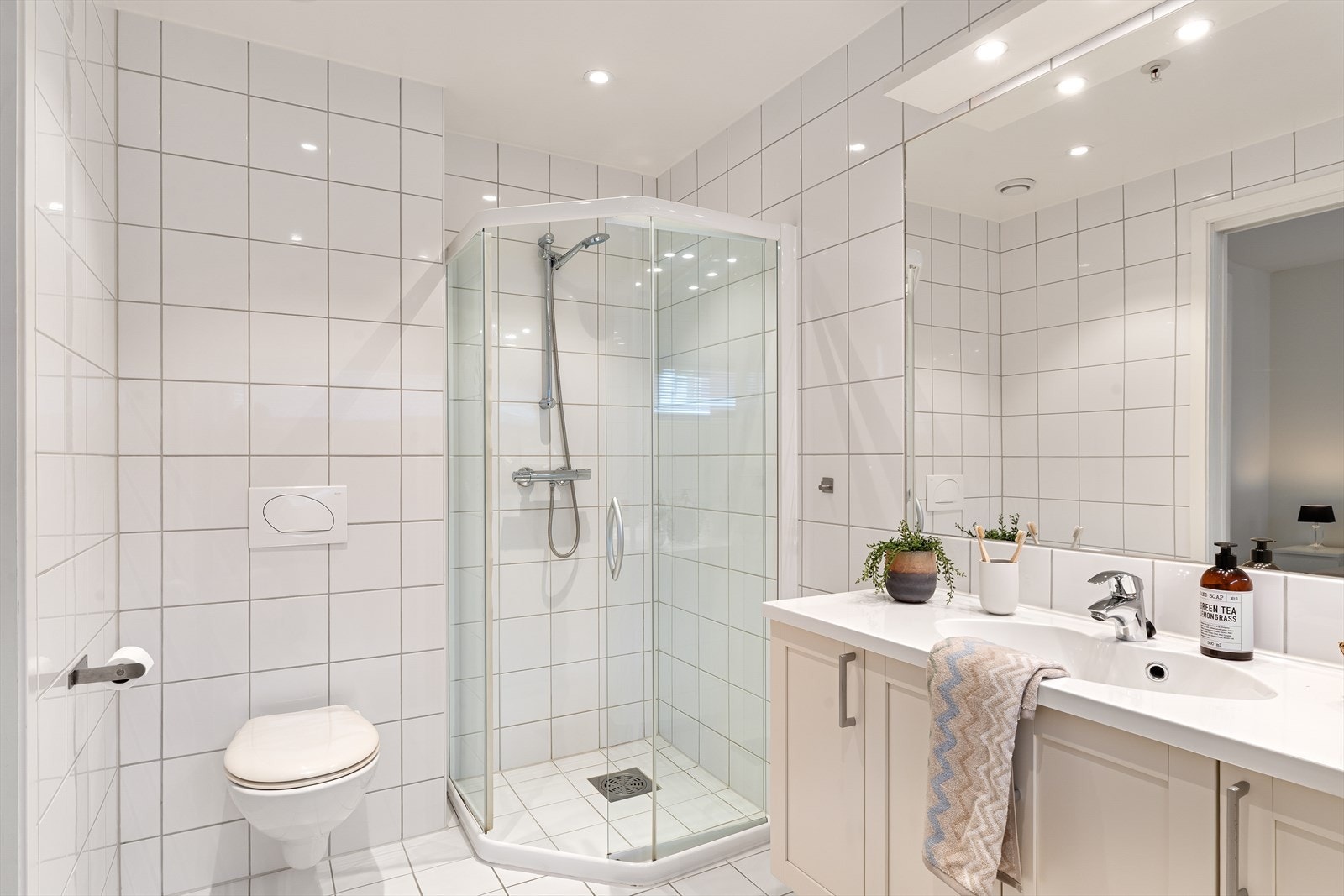 Badet tilknyttet soverommet har dusjnisje, vegghengt WC og stort møbel med vask Galleribilde