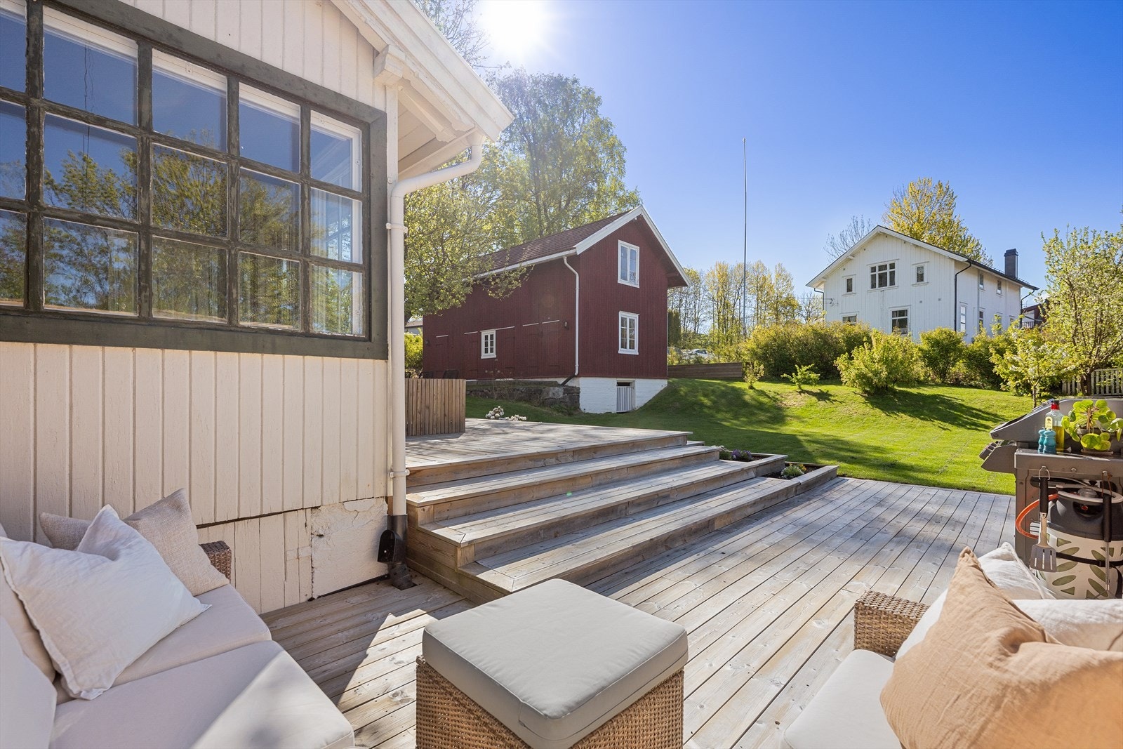 Terrassen er utført med trykkimpregnerte terrassebord og har integrerte blomsterkasser som skaper en fin overgang til hagen. Galleribilde