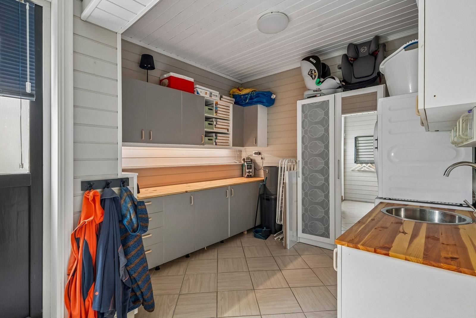 Praktisk innreiing på vaskerommet med benkeplate, nedfelt vask og opplegg for vaskemaskin. Galleribilde