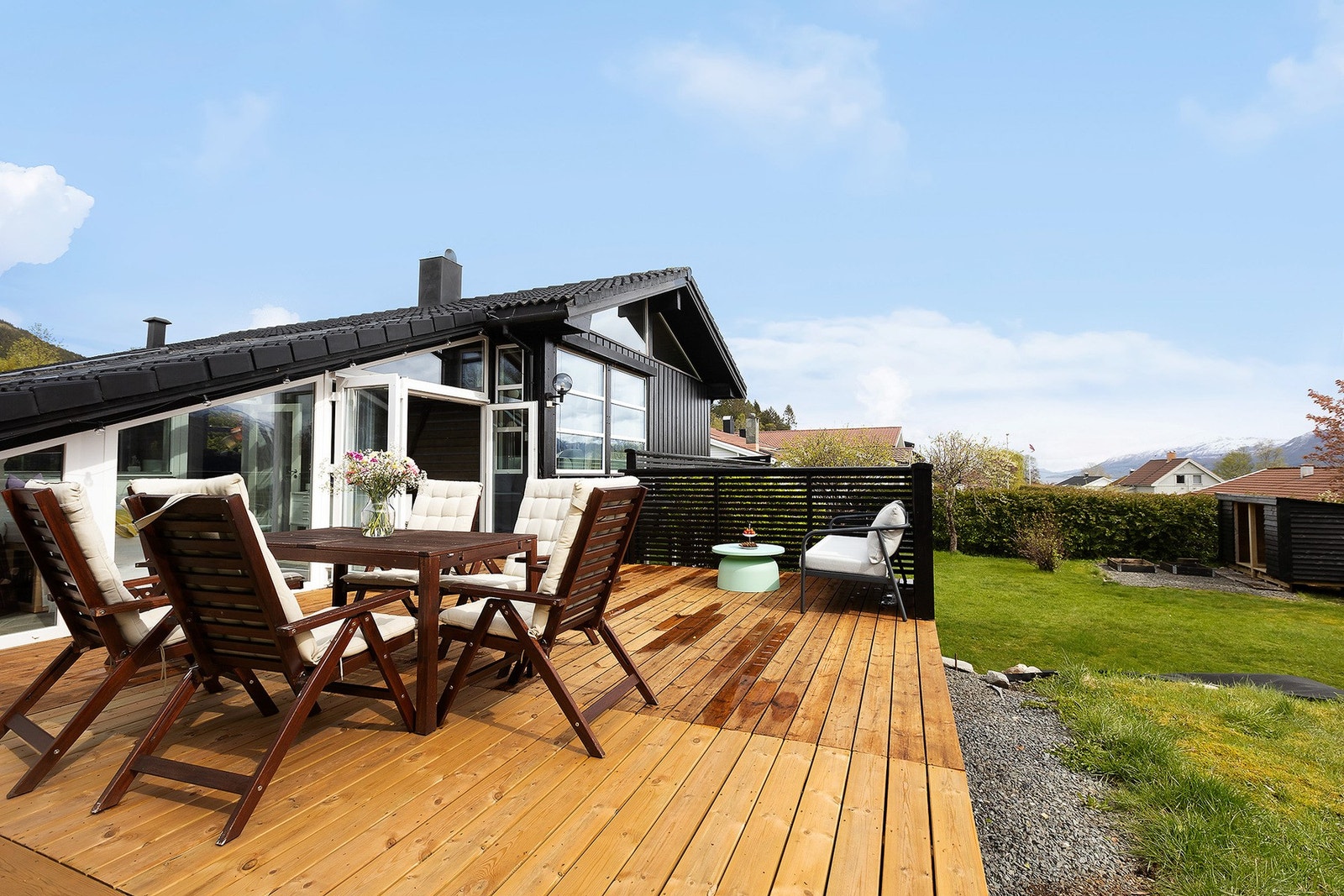 Pen opparbeidet uteområde med plen, veranda og en "gapahuk" som har være benyttet til hundehus. Galleribilde