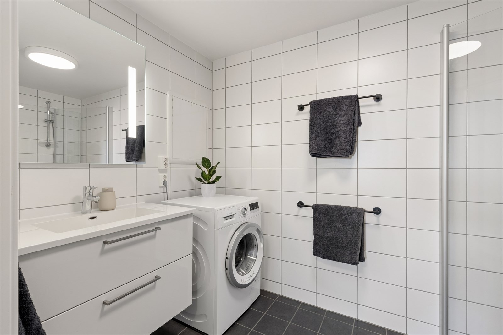 Baderommet er helfliset og har elektriske varmekabler i gulvet for økt komfort Det er også opplegg for vaskemaskin. Galleribilde