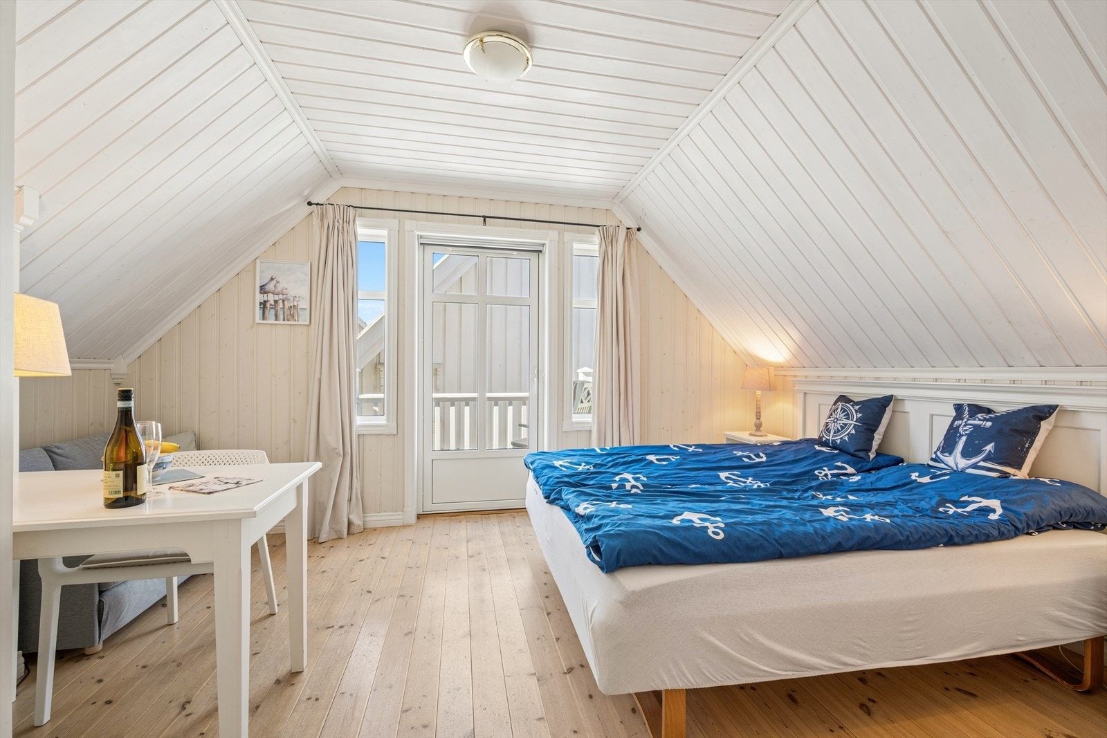Romslig soverom på loftet med lakkerte tregulv og plass til både dobbeltseng og sittegruppe. Galleribilde