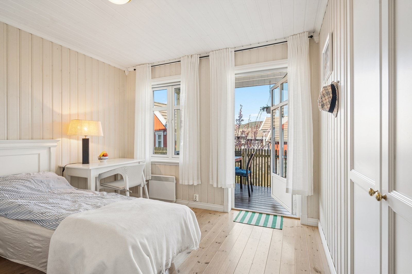 Fra det ene soverommet i underetasjen er det direkte utgang til en romslig, trebygget veranda. Galleribilde