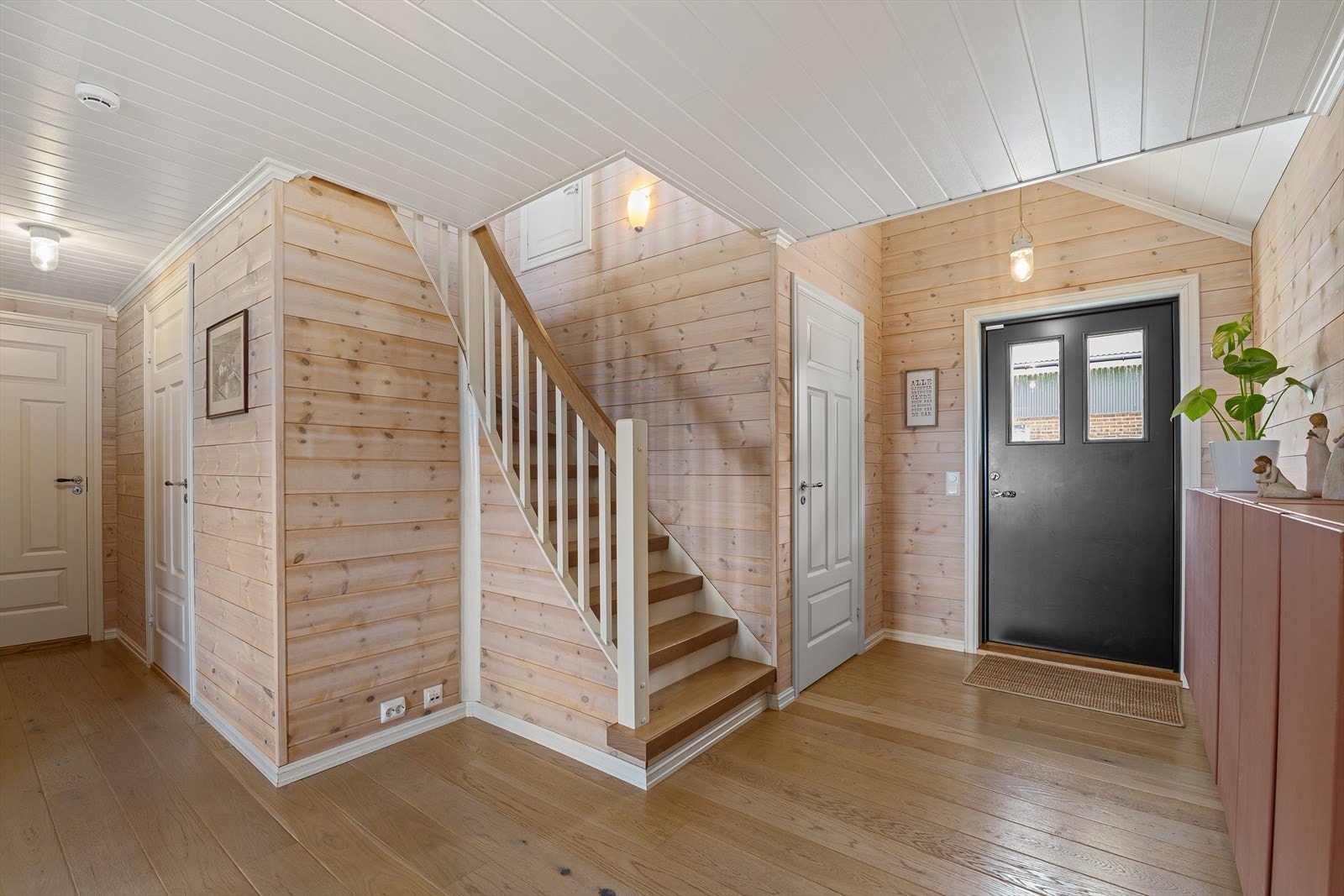 Hovedinngangen har en ny ytterdør fra 2014. Trappen med parkett i trinnene leder opp til andre etasje. Galleribilde