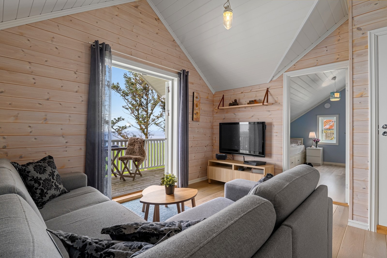 En lys og trivelig loftstue med plass til sofagruppe. Galleribilde