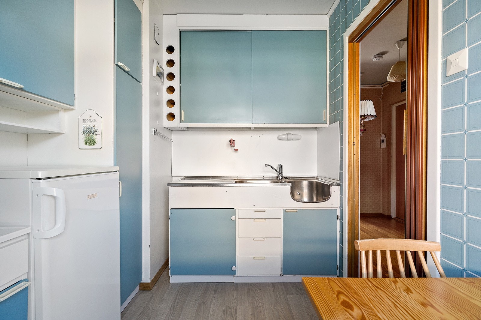 Eldre kjøkkeninnredning med slette fronter. Dobbelt oppvaskkum. Ventilator over komfyr er tilkoblet med utkast. Galleribilde