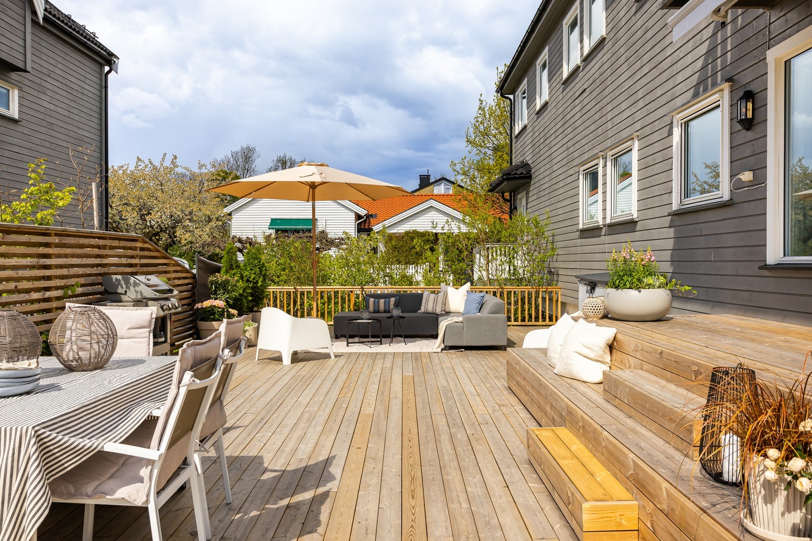 Terrassen har dekke av terrassebord, trapp med repos opp til terrassedøren, blomsterkasser, elektrisk markise, samt rekkverk og levegger i tre. Galleribilde