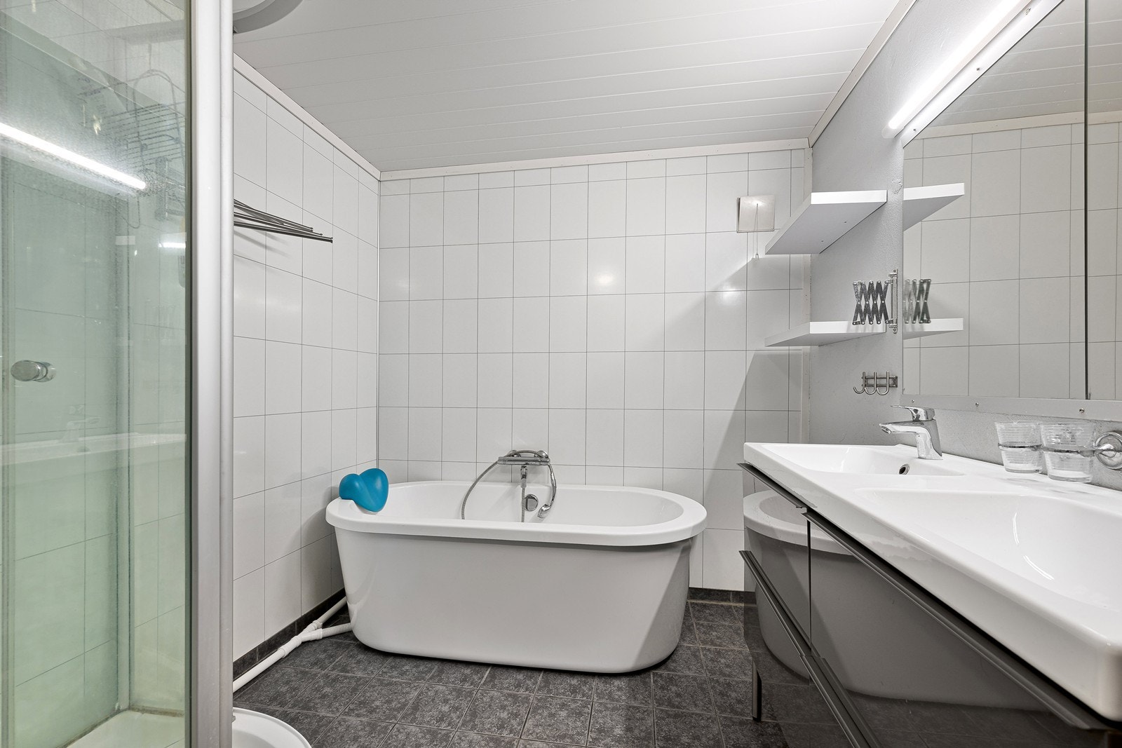 Badet har dobbelt servant i innredning, badekar, dusjkabinett og toalett Galleribilde
