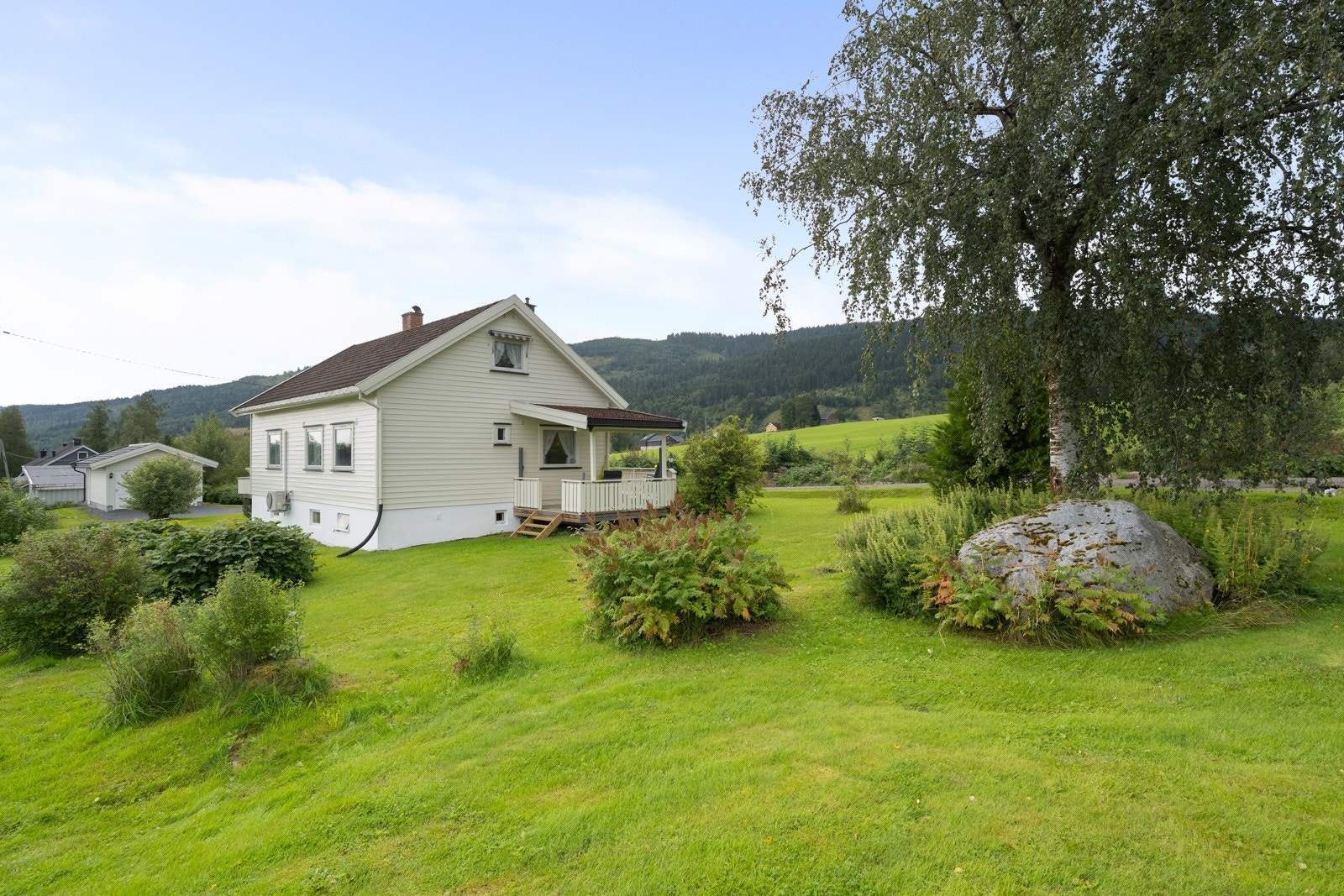Stor hage med plen og noe beplantning. Galleribilde