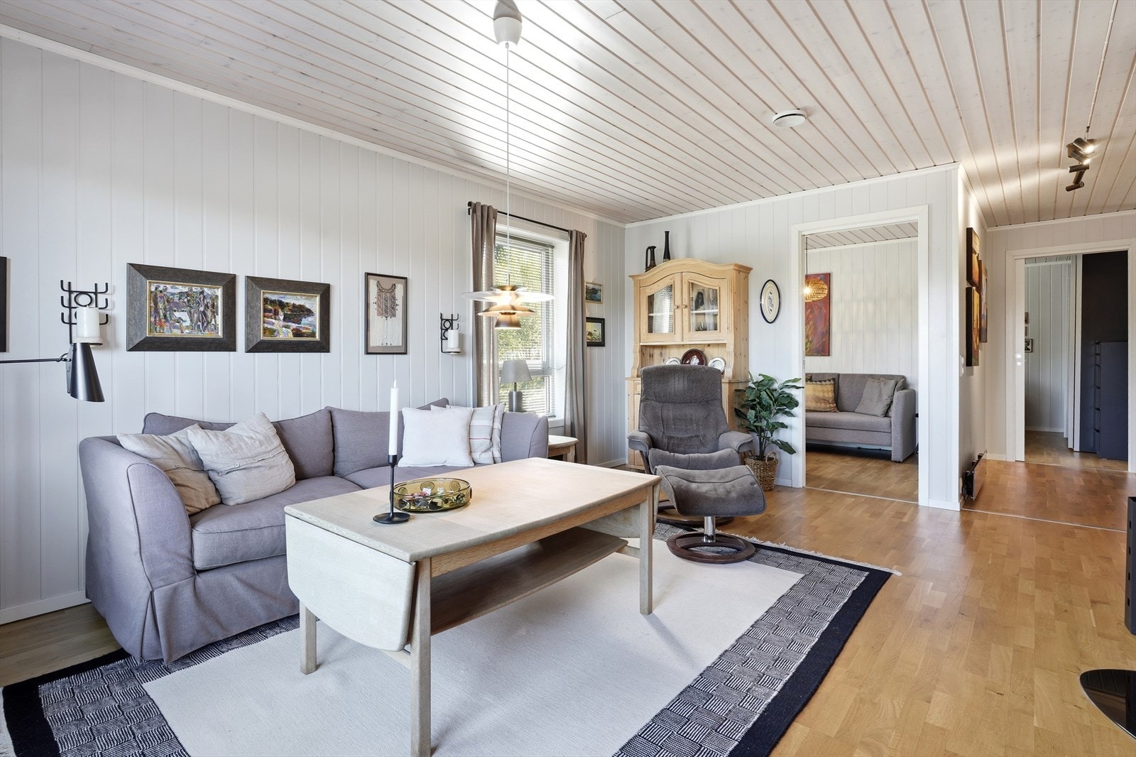 Stue med malte vegger og parkettgulv gir et solid grunnlag for interiør. Galleribilde