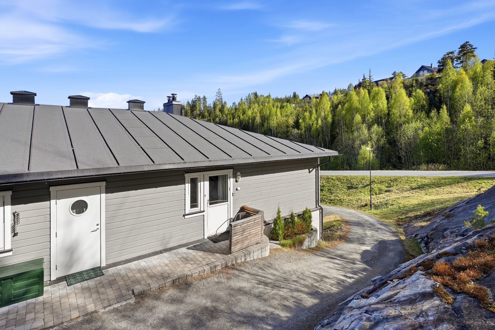 Uteplassen bak er opparbeidet med belegningsstein og tilgang via grusvei rundt bygningen. Galleribilde