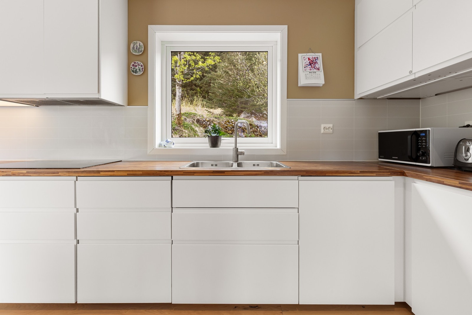 Benkeplate i tre, nedfelt kum og praktisk kitchenboard over benken. Galleribilde