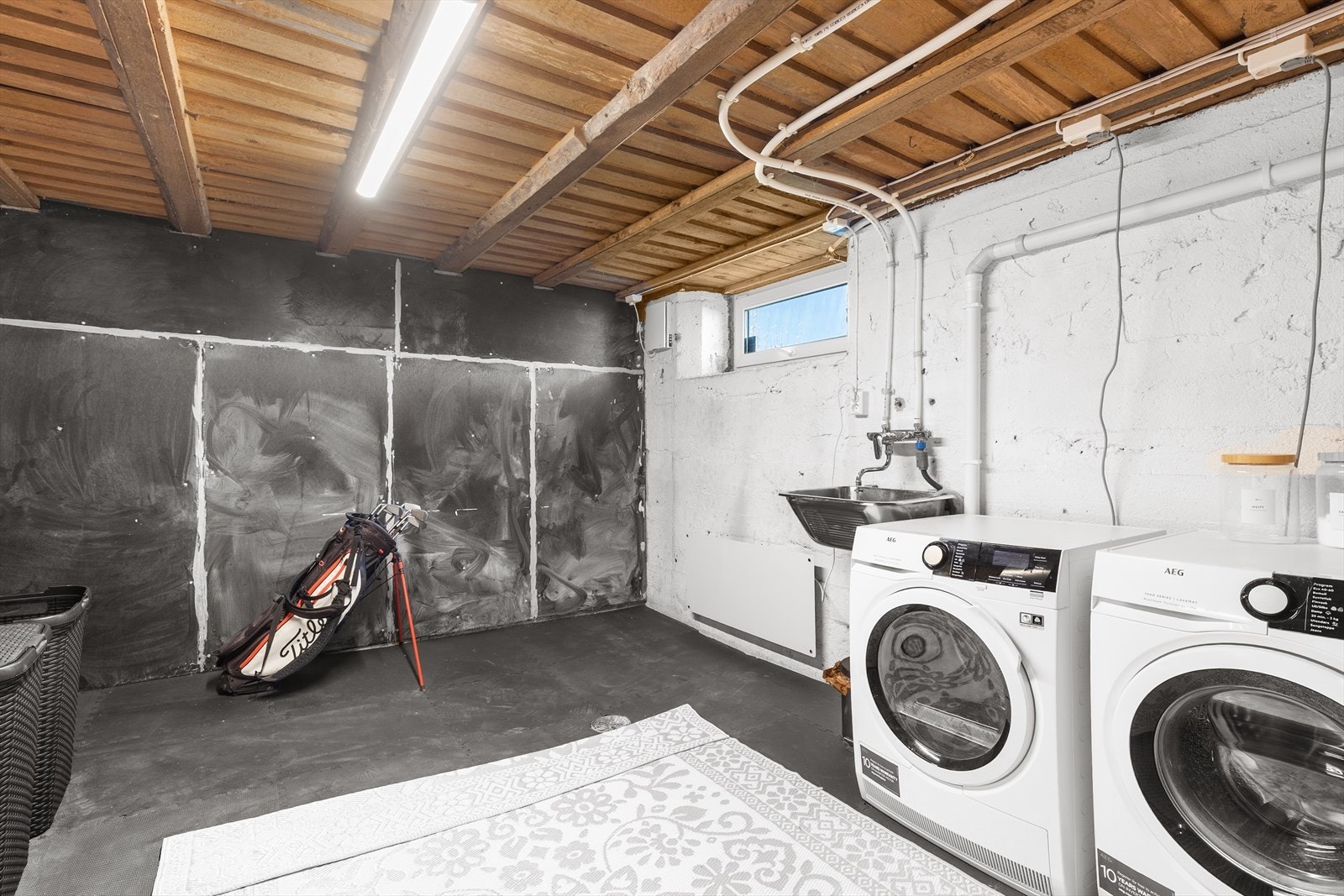 Praktisk vaskerom i kjelleren med opplegg for vaskemaskin, vaskekar og varmtvannstank. Galleribilde