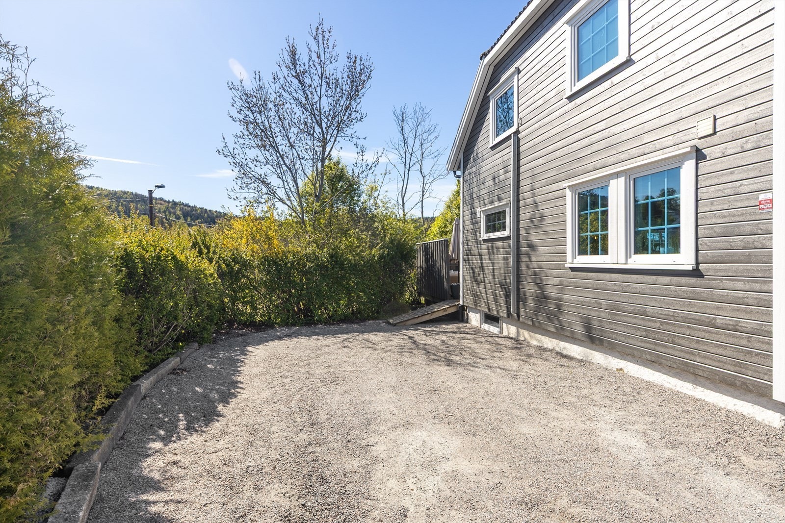 Tomten er relativt flat og pent opparbeidet. Hekk og beplantning rammer inn eiendommen og skaper en privat sone. Galleribilde