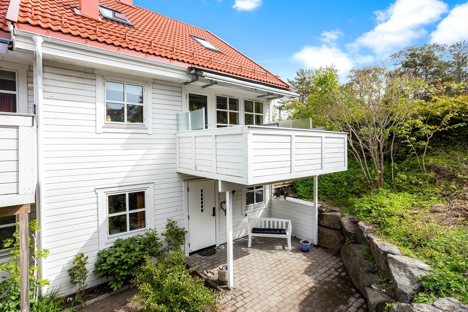 Boligen har et overbygget inngangsparti og en hyggelig, steinbelagt uteplass ved inngangen. Galleribilde