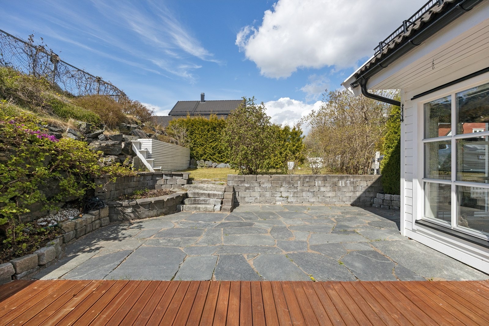 Pent opparbeidet uteplass med sten og platting. Galleribilde
