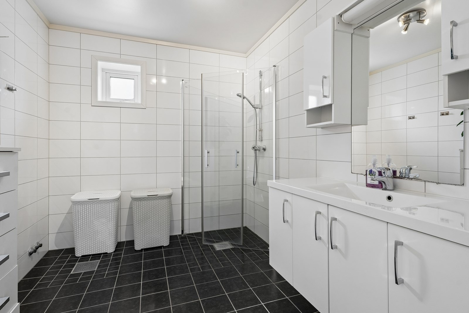 Badet ligg fint samla med soveromma, og er heilflisa med lyse og nøytrale fargar. Galleribilde