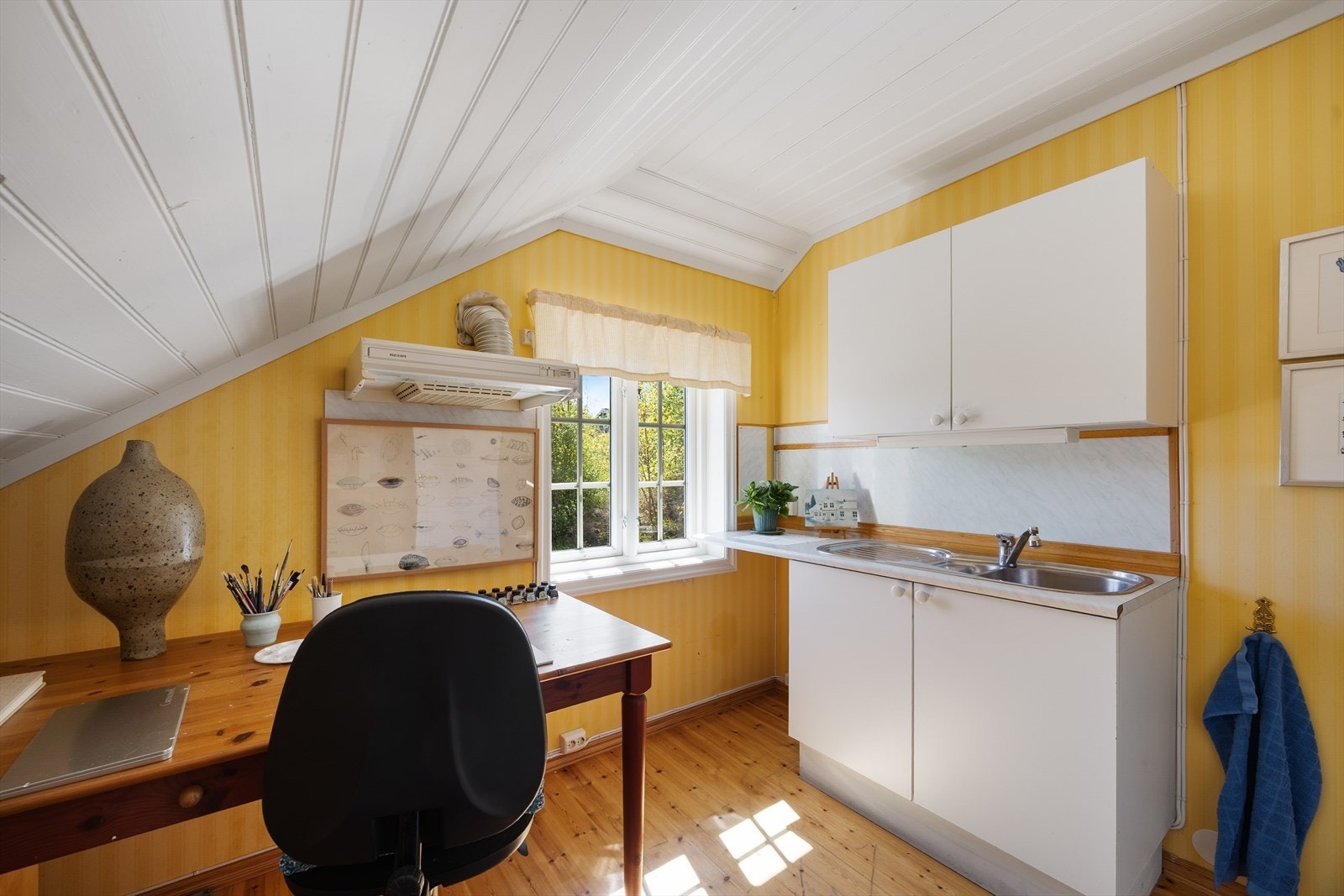 Dette rommet har tidligere vært brukt som et lite privat atelier og arbeidsrom. Dette rommet har også kjøkkeninnredning. Kjøkkenet har innredning med glatte fronter og benkeplaten er av laminat. Galleribilde