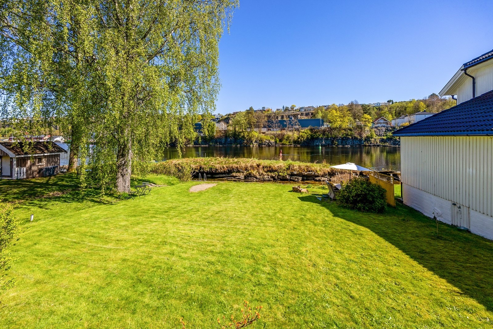 Hagen går ned til en kanal i Skienselva. Her kan du ha en liten båt, som ligger fortøyd beskyttet av Skjæret. Om du vil besøke en restaurant i Porsgrunn, tar du båten sørover et kvarters tid. Etter en varm sommerdag, er det svalt og godt på elva. Galleribilde