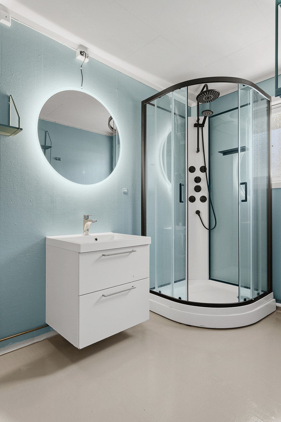 Badet er innredet med servant med skap, dusjhjørne, wc og opplegg for vaskemaskin. Galleribilde