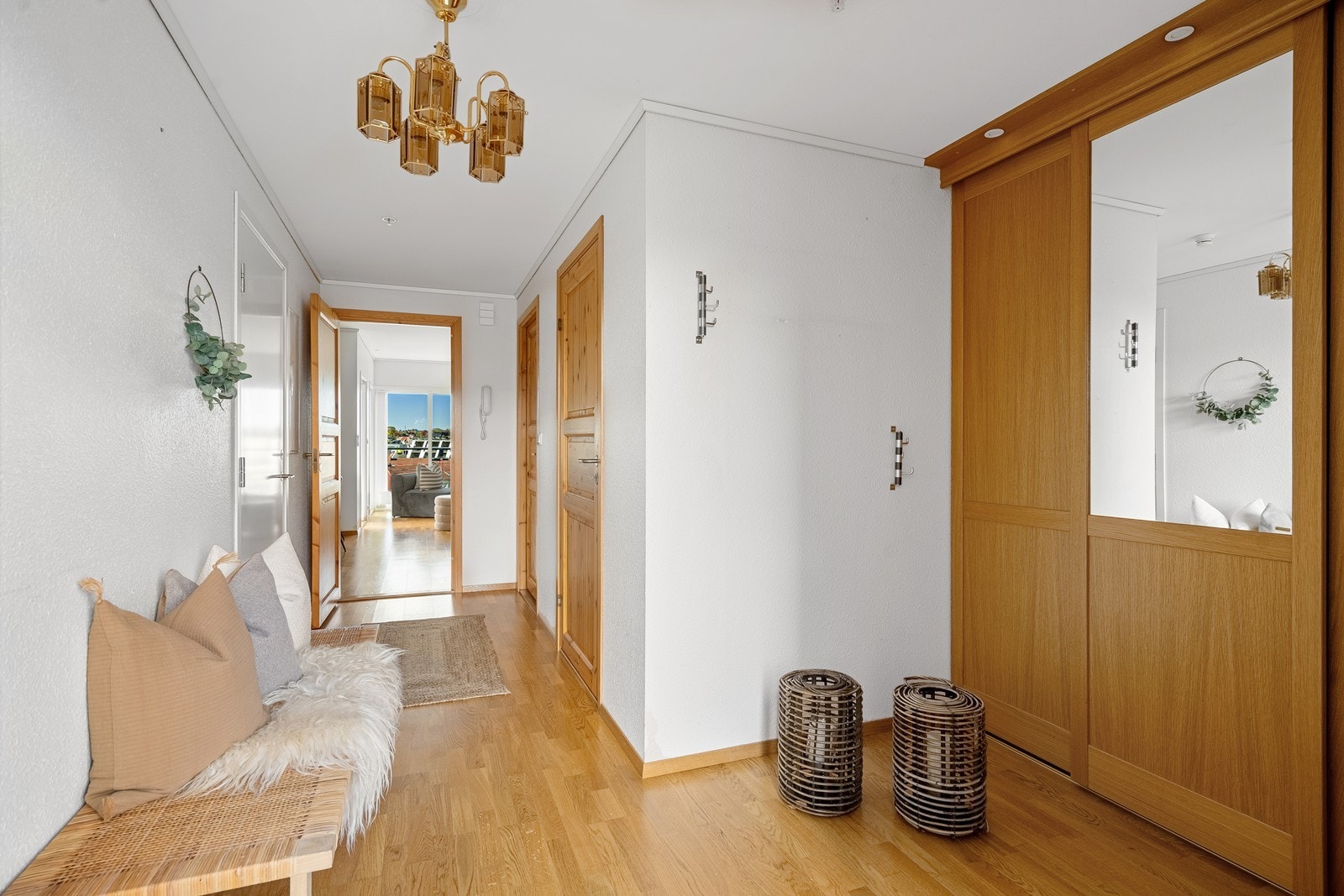 Lys og innbydende entre med praktisk skyvedørsgarderobe Galleribilde
