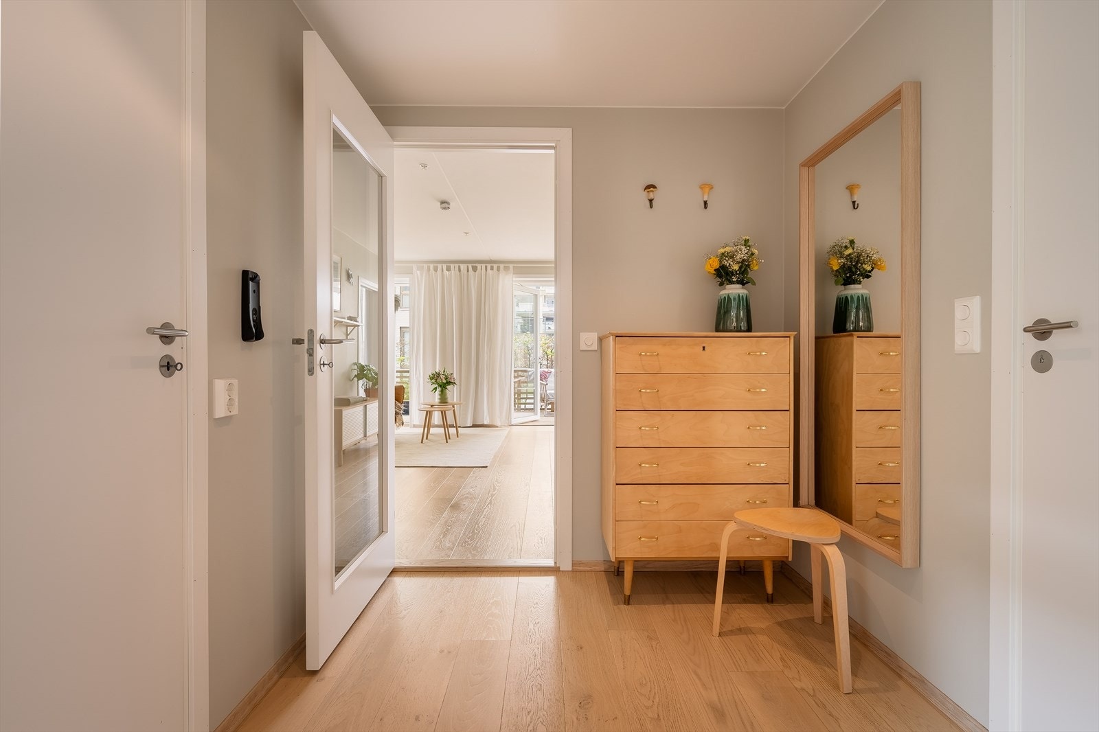 Entréen ønsker velkommen med downlights i taket og en glassdør som åpner opp mot stuen. Galleribilde