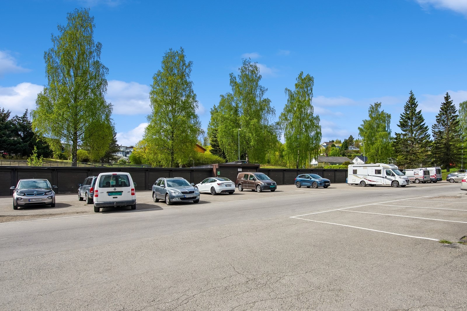 Asfaltert parkeringsområde på borettslagets tomt. Galleribilde