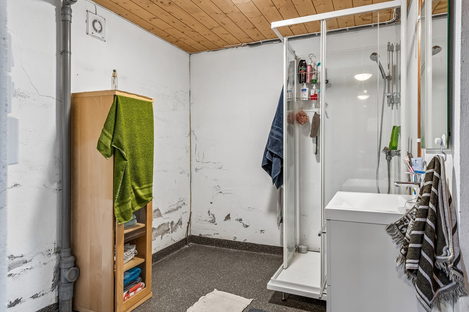Baderom i kjeller med dusjkabinett, servant i innredning og vinylbelegg på gulv fra 2021. Galleribilde