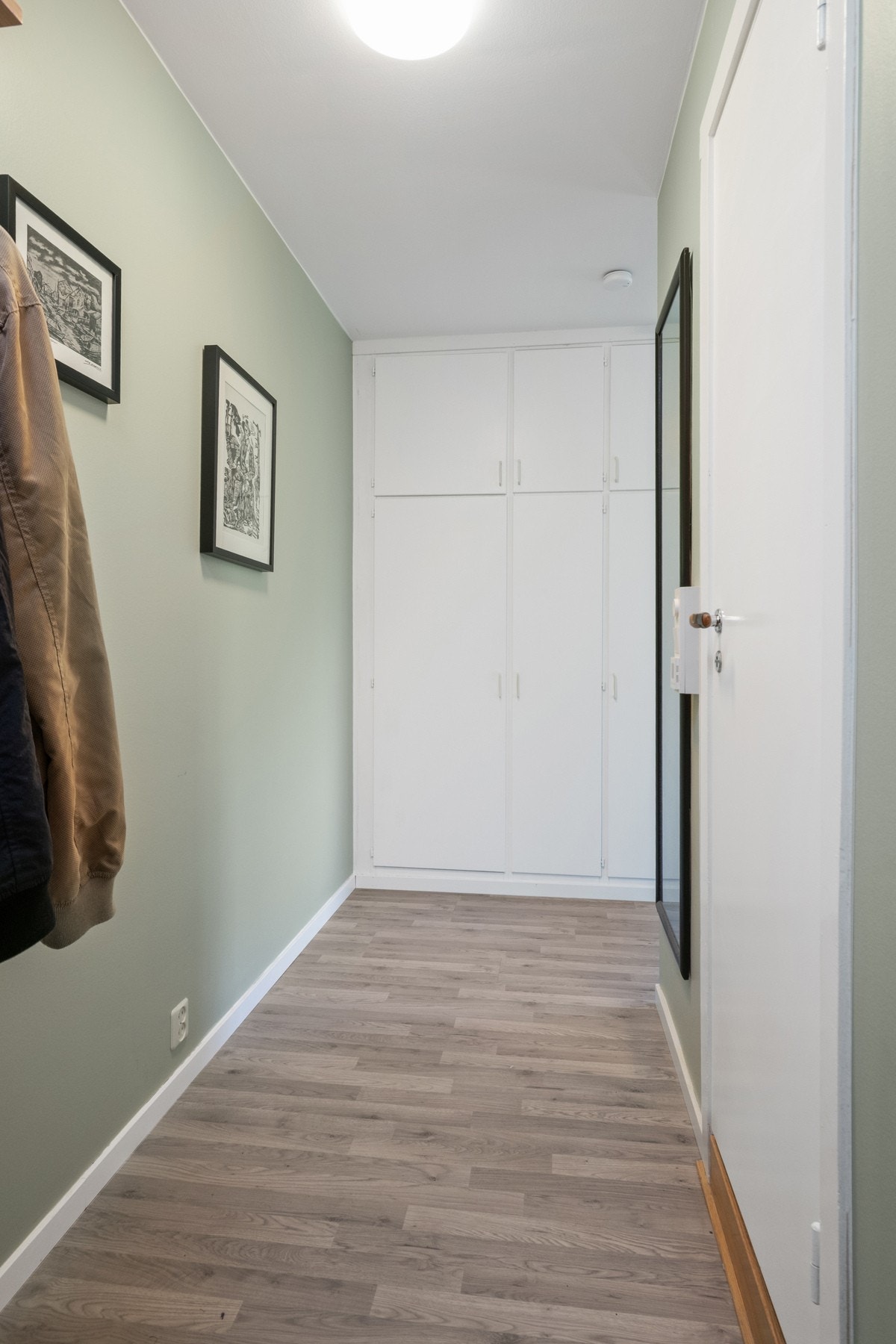 Gangen har nyere laminatgulv, mintgrønne vegger og innebygde garderobeskap. Galleribilde