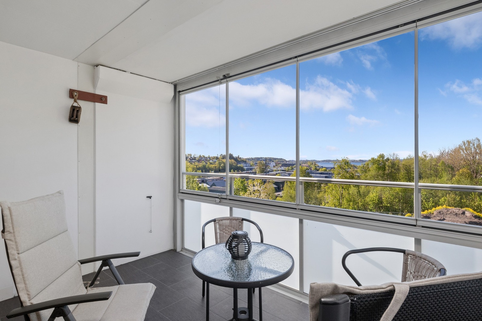 Fra stuen er det utgang til en innglasset balkong med fin utsikt mot sjøen i det fjerne. Galleribilde