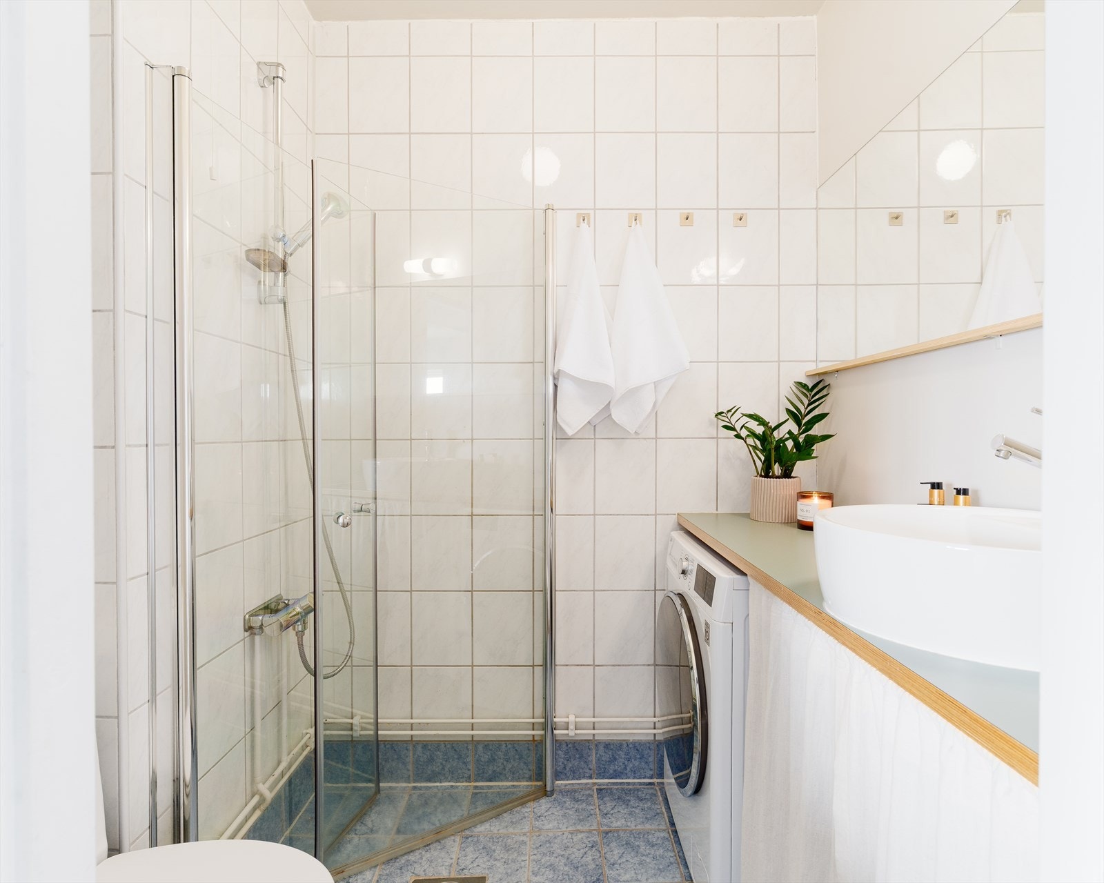 Badet er flislagt med fliser på gulv og vegger, og har termostatstyrte varmekabler i gulv og har opplegg for vaskemaskin. Galleribilde
