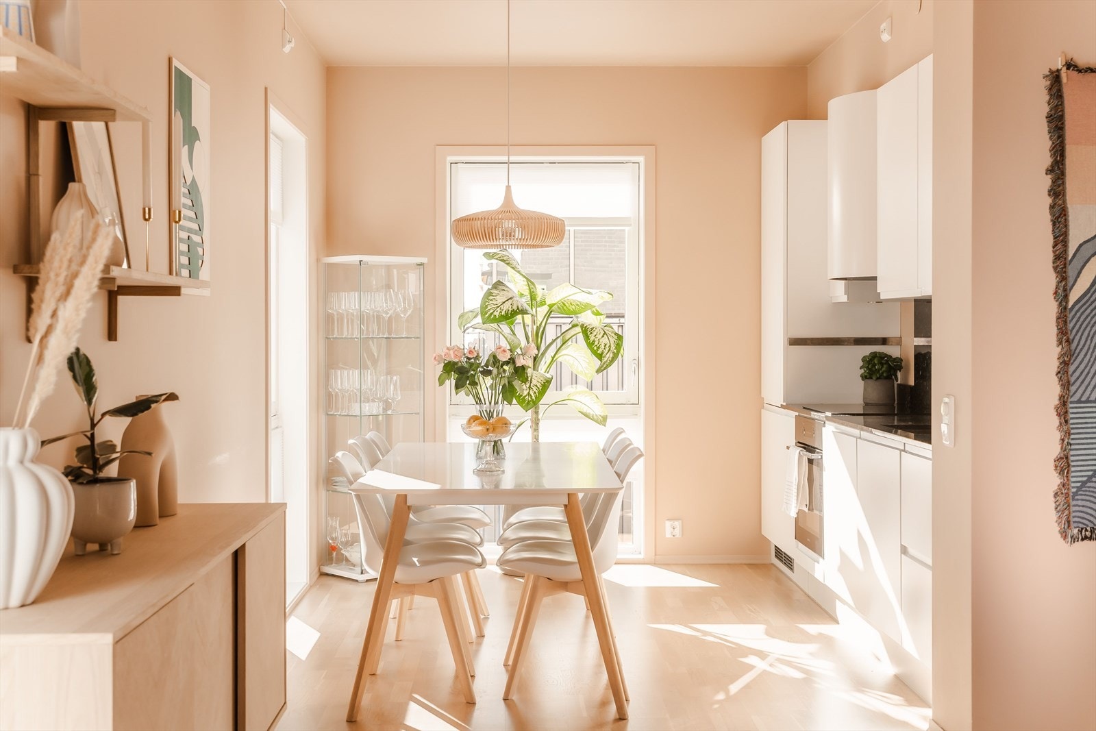 Kjøkkeninnredningen har slette, hvite fronter, mørk benkeplate av granitt og en stilren utførelse som står fint til de varme veggtonene og parkettgulvet. Galleribilde