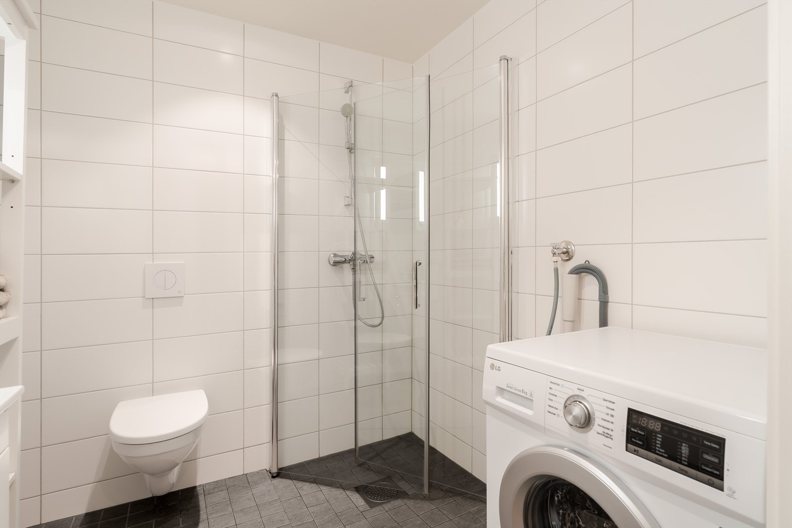 Leiligheten har to flislagte bad, noe som gir en svært praktisk løsning i hverdagen. Det største badet er på ca. 4 m² og har hvite fliser på vegg, mørke fliser på gulv og elektriske varmekabler. Galleribilde