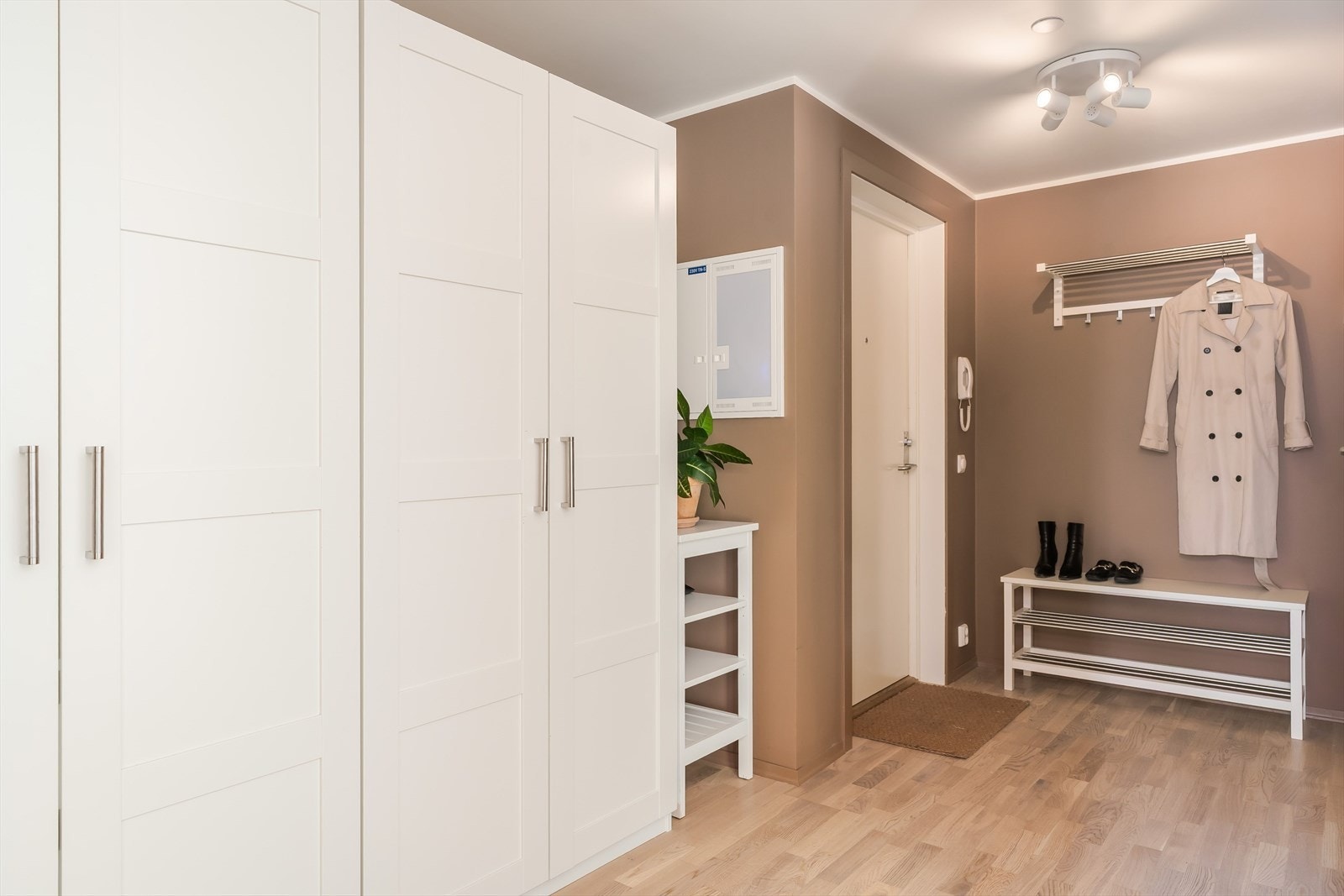 Her er det god plass til sko og yttertøy, garderobeskap langs vegg og en praktisk benkesone ved inngangen. Galleribilde