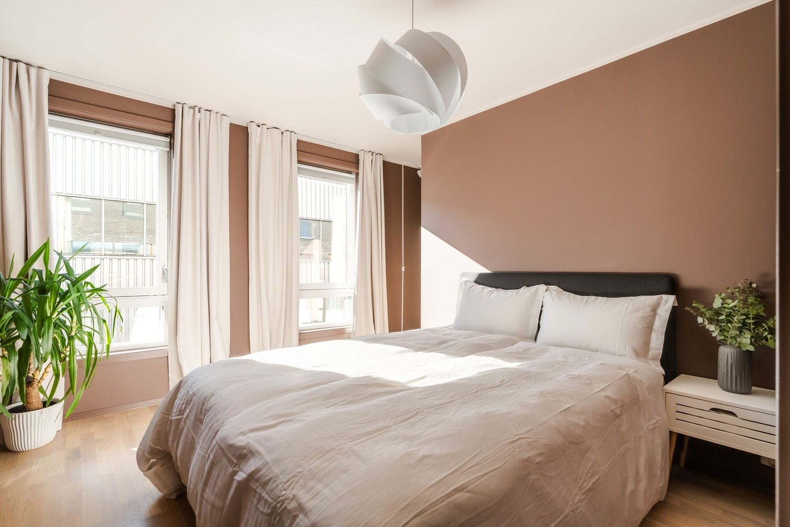 Leiligheten har to soverom av god størrelse. Hovedsoverommet er på ca. 14 m² og fremstår som et lunt og behagelig rom med parkettgulv, varme veggtoner og to vinduer som slipper inn godt med dagslys. Galleribilde