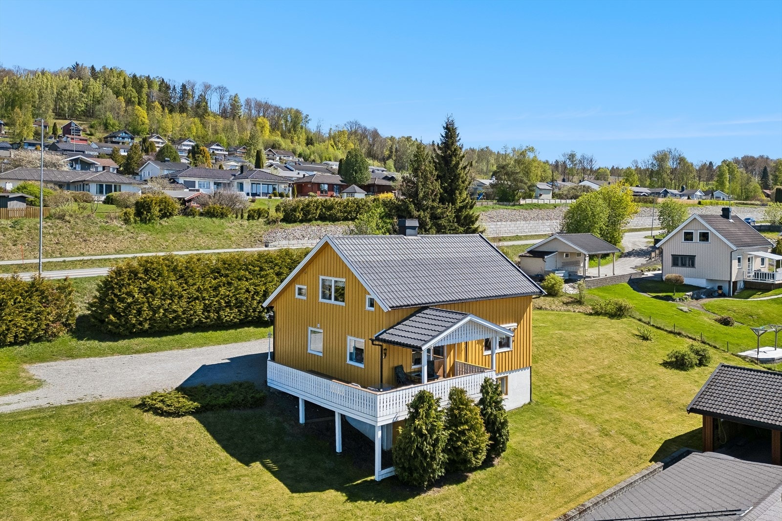 Gruset innkjøring og gårdsplass med god plass til parkering foran boligen og garasjen. Galleribilde