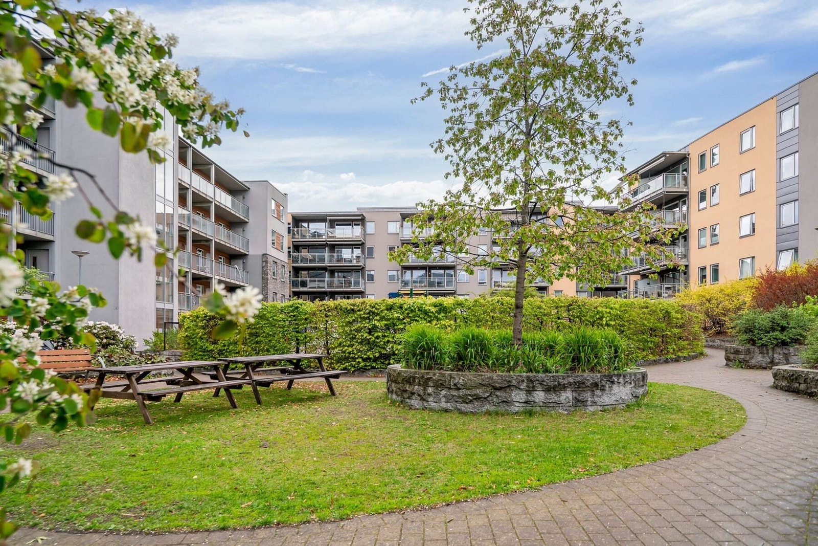 På sommeren er bakgården en frodig og hyggelig plass, som fungerer som samlingspunkt for beboerne i sameiet Galleribilde