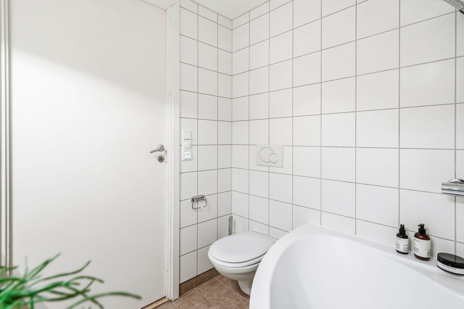 Badet har en god størrelse og er innredet med servantinnredning, badekar, vegghengt toalett og opplegg for vaskemaskin Galleribilde