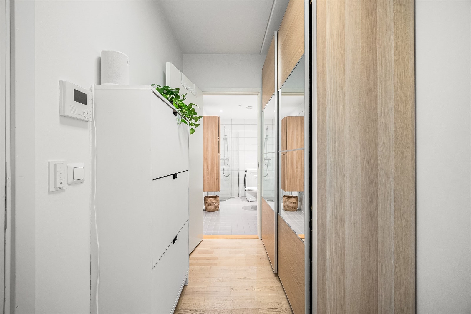 God plass til oppbevaring og oppheng av yttertøy og sko, samt et stort garderobeskap med speil. Fra entréen er det direkte tilgang til badet og videre inn i leilighetens sosiale sone Galleribilde