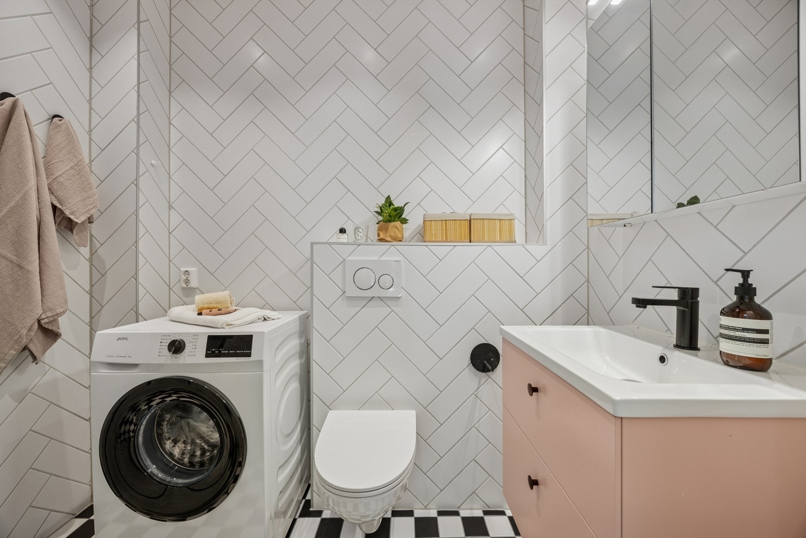 Badet er nytt fra 2019 og er flislagt med stilige fiskebensfliser på vegger. Bildet er hentet fra forrige salsgoppgave og det står en annen vaskemaskin der i dag. Galleribilde