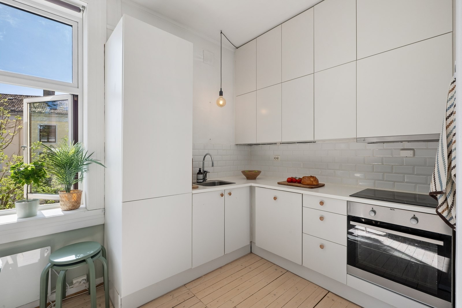 Lyst og moderne kjøkken fra 2014. Innredning med glatte fronter og laminat benkeplate. Galleribilde