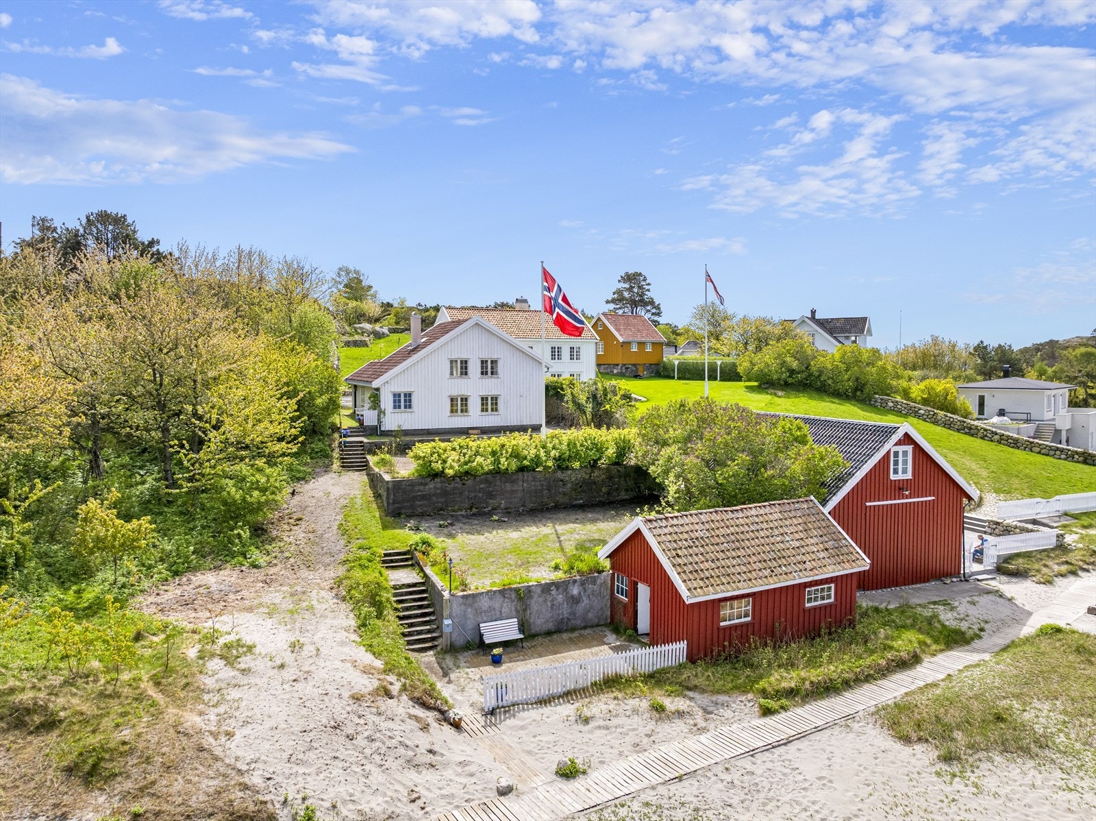 Eiendommen ligger høyt og fritt i terreng med tilbaketrukket uteplass over flere nivåer med fritt utsyn og begrenset innsyn. Fra sjøbod med tilhørende platting ligger man helt ned til stranden. Galleribilde