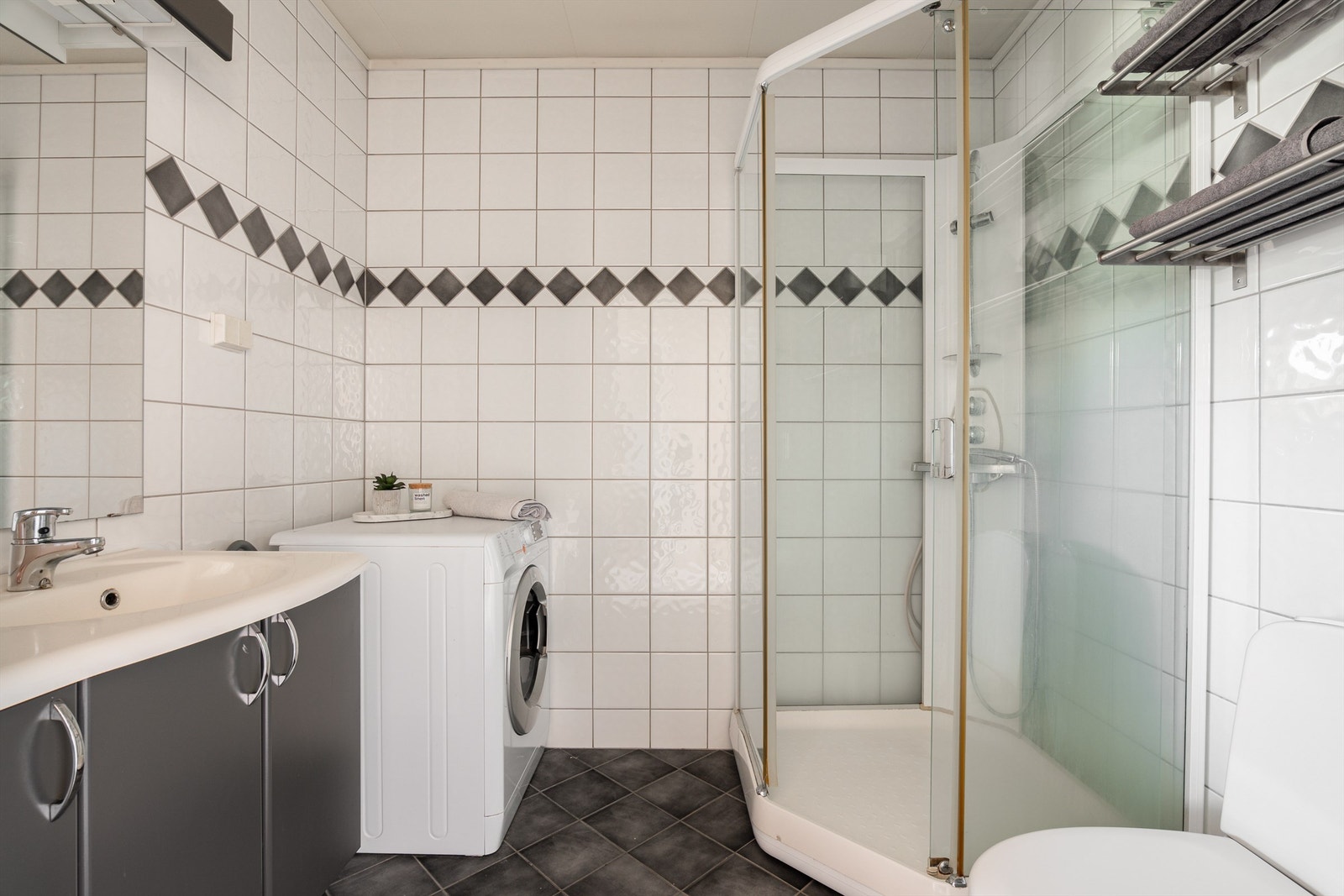 Badet er fra byggeåret og i god stand. Dusjkabinett begrenser vann på gulvet og veggene som alle er flislagt. I gulvet er det varmekabler. Galleribilde