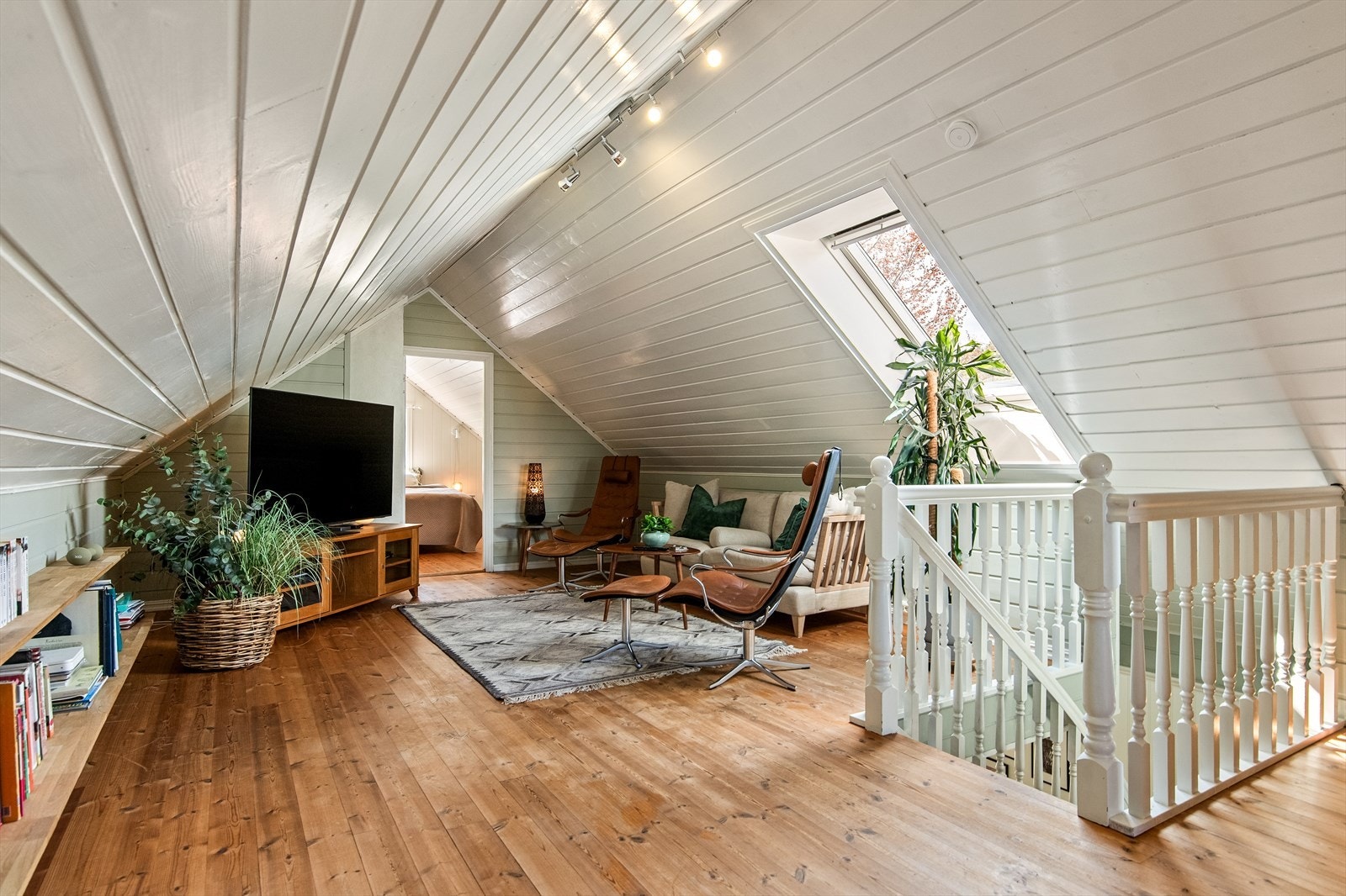 Loftstuen ligger skjermet til i 2. etasje og fungerer fint som ekstra oppholdsrom eller ungdomsavdeling. Rommet har mønehimling, Velux-vindu og gode lysforhold. Galleribilde