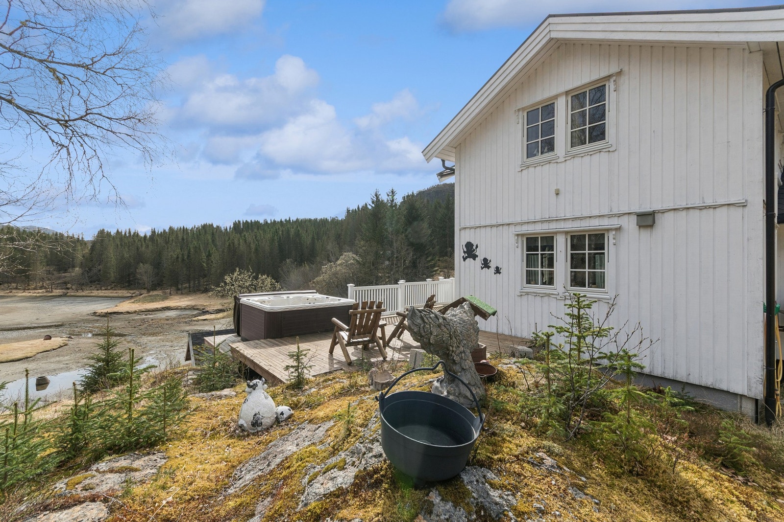 Romslig tomt som er en kombinasjon av opparbeidet med plen, gruset parkeringsareal og naturtomt. Galleribilde