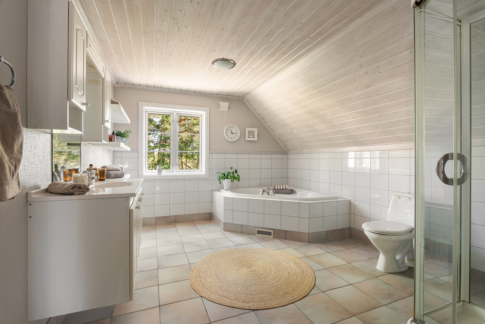 Badet er fra boligens byggeår, stort og velutstyrt med både badekar og dusjkabinett som gir lite vannpåkjenning på gulv og vegger. Galleribilde