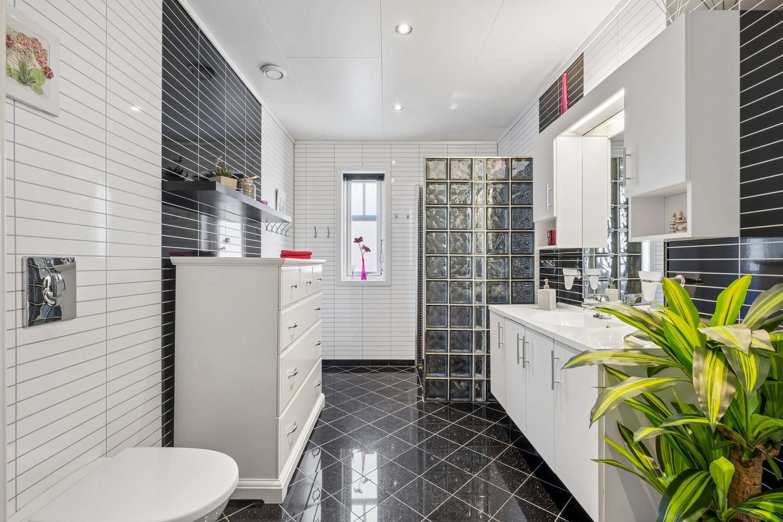 Badet har baderomspanel på vegger og flislagt gulv med varmekabler. Innredet med servantinnredning, speil, overskap og vegghengt toalett. Galleribilde