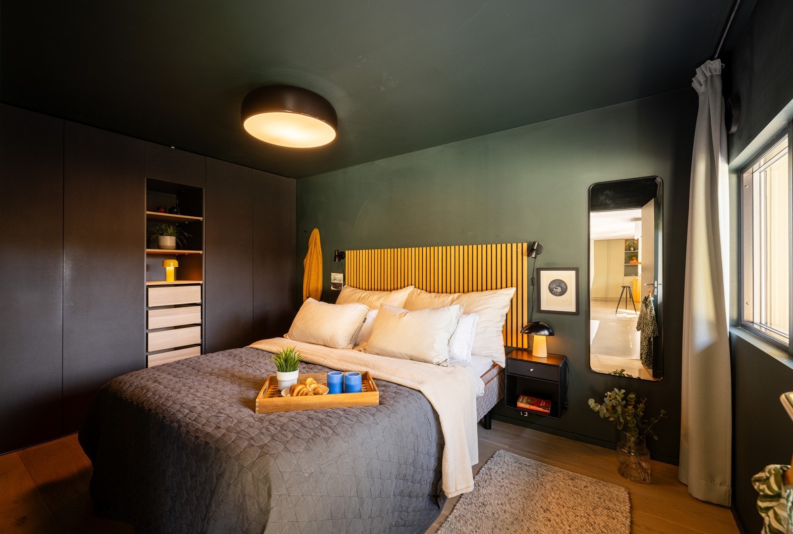Hovedsoverom med hotellinspirert uttrykk, mørke farger og integrert garderobeløsning Galleribilde