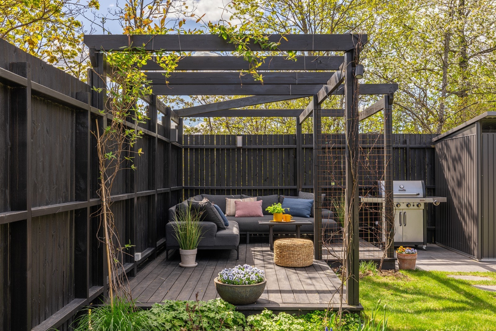 Uteplassen er tilrettelagt for lange sommerdager med sofa, bord og beplantning Galleribilde