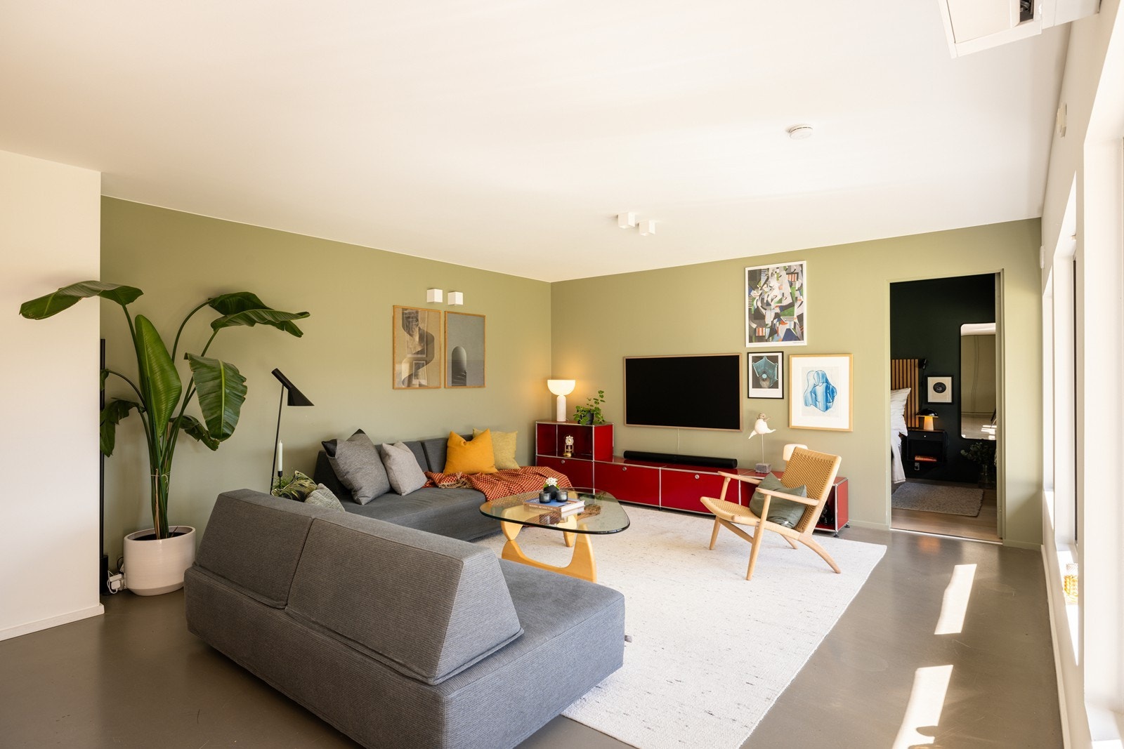 Stuen har god plass til sofagruppe og store vindusflater mot den skjermede atriumshagen. Galleribilde